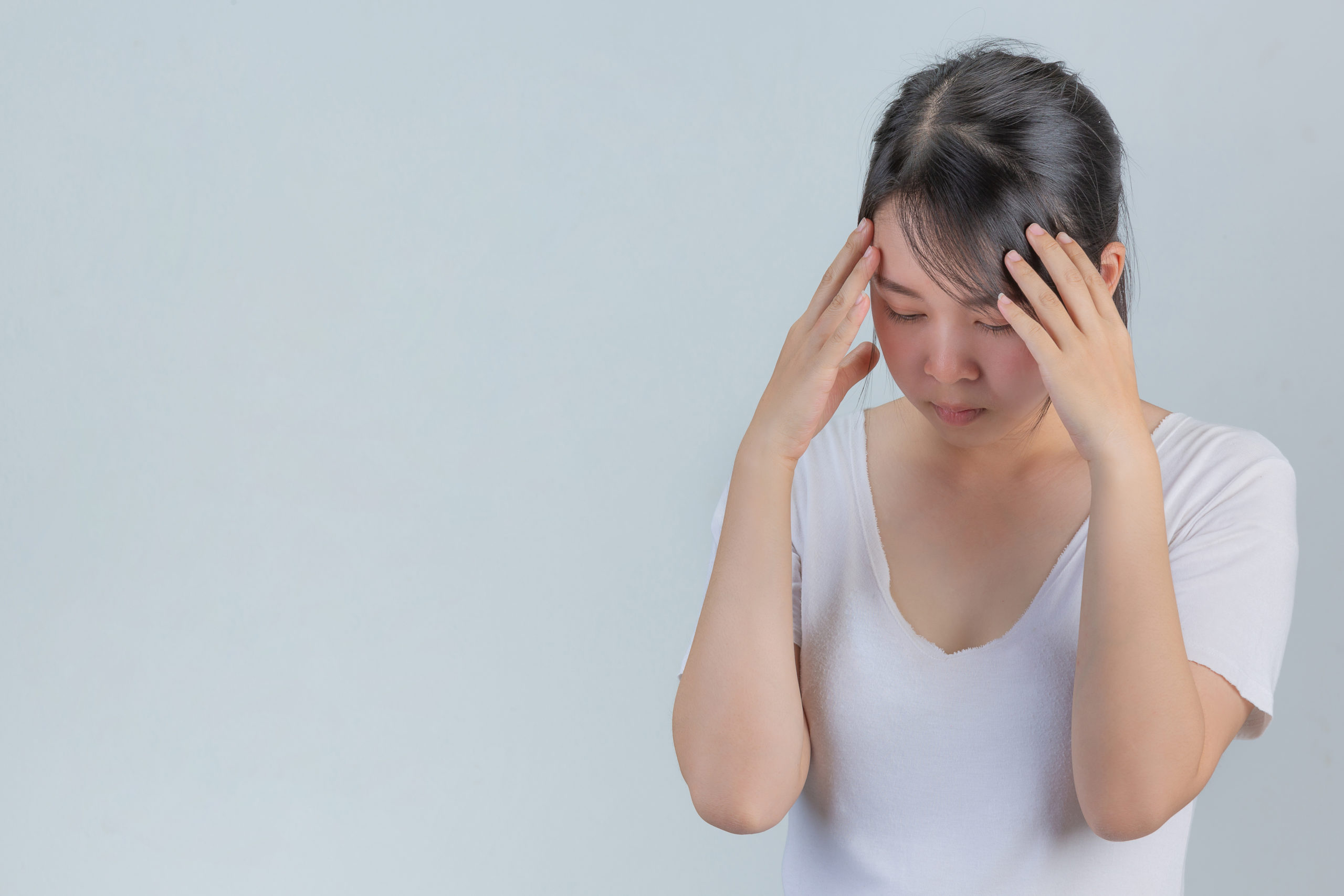 woman showing signs stress gray wall scaled 2 10 Lý do gây rụng tóc ở Phụ nữ sau tuổi 30 Go1care
